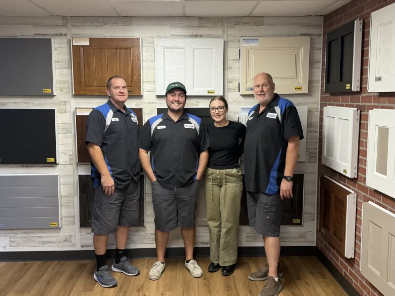 A white modern farmhouse with a large, dark gray carriage-style garage door and black-trimmed windows.